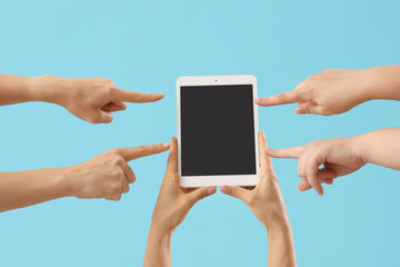 Poster - Women pointing at blank tablet computer on blue background