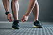 © peopleimages.com - Workout, gym and man tie shoes for exercise, training and fitness in health center with feet. Hands, shoelace and sport facility with runner sneakers, legs and athlete on ground for wellness