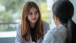 © Naknakhone - Asian woman patient visit and consult health problem with young doctor. Attractive therapist practitioner work to explain diagnosis in office hospital to give treatment to sick.