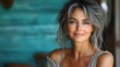 © julija - charismatic middleaged woman portrait genuine smile confident pose vibrant turquoise background natural lighting enhancing features