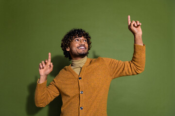 Wall Mural - Photo portrait of handsome young guy dance point look up empty space dressed stylish brown garment isolated on khaki color background