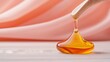 © Nadia - A glass bottle with a wooden spoon is in front of a pink background as a drop of oil is being poured