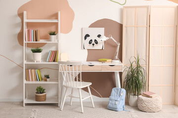 Wall Mural - Modern school desk with stationery and backpack in room near color wall