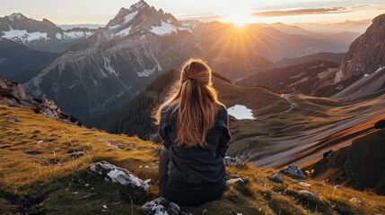 back view of a man sitting on a mountain ridge. the serene hiker has reached his goal. beautiful sce