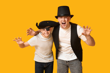 Wall Mural - Father with his son dressed for Halloween on yellow background