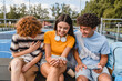 © InsideCreativeHouse - Group of smiling friends teenagers high school pupils college students laughing out having fun watching funny video using gadgets smart phones handing out in sport court yard outside after lessons