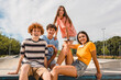 © InsideCreativeHouse - Photo of happy smiling friends teenagers high school pupils college students spending time summer holiday having fun meeting hanging out outside in skate green nature park looking at camera