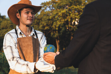 Wall Mural - Eco-business company empower farmer with eco-friendly farming practice and clean agricultural technology. Cultivate sustainable future and holding Earth globe symbolize commitment to environment.Gyre