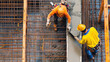 © Luluraschi - construction workers pouring concrete into a beam formwork on a building site