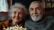 © Pornfa - Elderly couple watching a movie together in a home theater, sharing popcorn and smiles