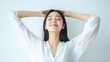 © thanarak - Radiant Asian Woman Peacefully Stretching Arms on White Background