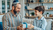 © NewFresh  - happy father and son with gift box looking at each other at home