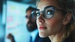 © Phiranchaya Thatham - Focused businesswoman wearing glasses looks up thoughtfully during a meeting.