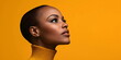 © Vasiliy - Elegant profile portrait of bald woman with flawless skin in yellow turtleneck against orange background for beauty and confidence concepts