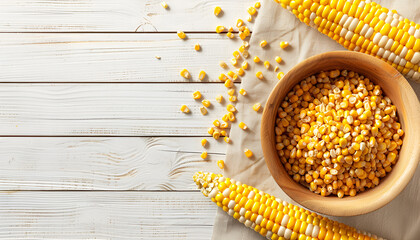 Bowl with corn seeds and ripe corn cobs on wooden table