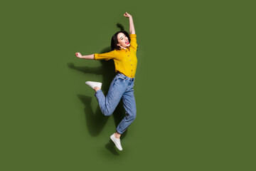 Poster - Full length photo of shiny attractive lady dressed yellow blouse jumping high empty space isolated green color background