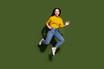 Sticker - Full length photo of shiny attractive lady dressed yellow blouse jumping high walking empty space isolated green color background