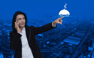 Wall Mural - Businesswoman talking on her cell phone and pointing finger to restaurant cloche flat icon over modern city tower, street, expressway and skyscraper, Business food delivery online concept