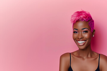 Portrait de face femme noire ou métisse, créole, souriante avec une coupe de cheveux rose vif, posée sur un fond assorti de couleur rose espace négatif copyspace