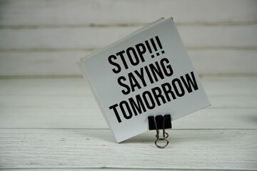 Stop Saying Tomorrow text message write on sticky note on wooden background