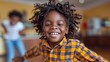 © amixstudio - A joyful young boy with curly hair wearing a yellow and black plaid shirt, smiling widely. The background shows a cozy indoor setting with soft lighting