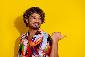 Photo of nice young man look indicate finger empty space wear shirt isolated on yellow color background