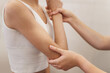 © illustrissima - posture correction. Chiropractic, back pain relief. Professional female physical therapist doing shoulder, elbow and hand massage in hospital elbow