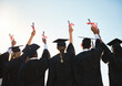 © peopleimages.com - Graduation, diploma or back of students with degree at university for education, opportunity or success. Sky, scholarship or group of proud people with college certificate, hands up or achievement