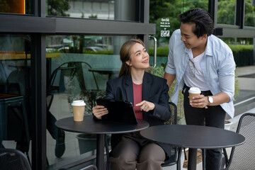 Businesswoman discussing with friend to plan meeting in modern coffee shop