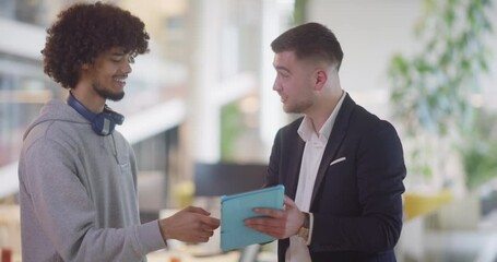 Wall Mural - In a modern office setting, an African American businessman engages in a discussion with his director, using a tablet to address business challenges, symbolizing collaboration and technology