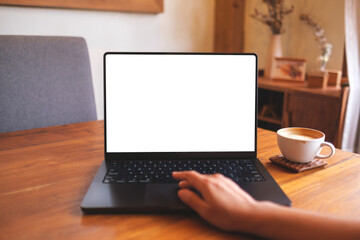 Mockup image of a woman using and touching on computer laptop touchpad with blank desktop screen at home