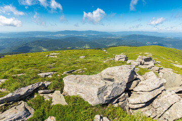 Wall Mural - high mountain summer landscape. meadow with huge stones among the grass on top of a hill near the sl