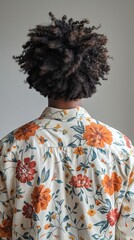 Rear view of a person wearing a floral shirt with curly hair.