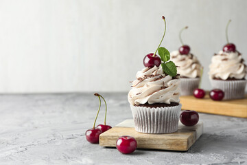 Poster - Delicious cupcake with cream and cherries on grey textured table, space for text