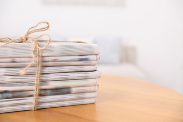 Canvas Print - Stack of many newspapers in different languages on wooden table, space for text