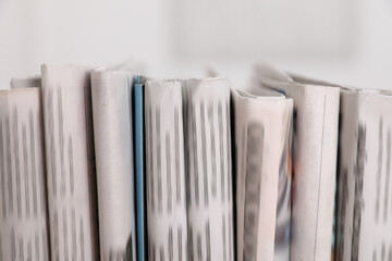 Canvas Print - Many newspapers in different languages on blurred background, closeup