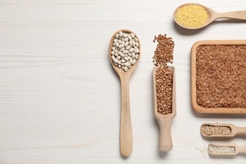 Canvas Print - Different types of legumes and cereals on white wooden table, flat lay. Space for text