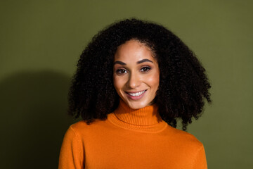 Sticker - Photo of adorable gorgeous positive woman with curly hairdo dressed orange turtleneck smiling isolated on dark khaki color background