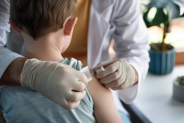 one unrecognizable doctor putting a patch on the little boy's shoulder after successful vaccination 
