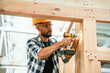 © standret - Busy, drilling the hole. Industrial worker in wooden warehouse