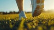 © pinporn manosri - A close-up of sneakers running on a grassy field, with blades of grass bending underfoot, showcasing outdoor activity