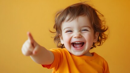 Child in Orange Tee Laughing, Pointing, Warm Cream Background