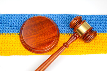 wooden gavel for auctions, bidding and judicial law on the background of the Ukrainian flag. symbol of justice and judgment