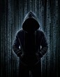© Carlostock - Mysterious person wearing a long-sleeve jacket, face not visible, giving the impression of a digital criminal like a hacker
