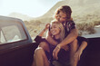 © Marko Geber - Couple cuddling in the back of a pickup truck during a sunny road trip