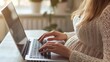 © 69 - A pregnant woman using a laptop at work, focusing on her hands typing on the keyboard, emphasizing the combination of career and motherhood.