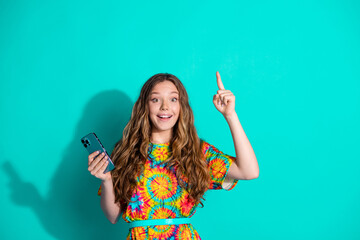 Sticker - Photo portrait of attractive teen woman hold device point up eureka dressed stylish colorful clothes isolated on cyan color background