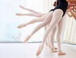 © Nina2024/peopleimages.com - Ballet, dance and legs of people in studio together for theatre performance, recital or rehearsal. Balance, learning and stretching with ballerina group in class for art, creative expression or skill