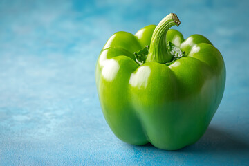 Canvas Print - A fresh green bell pepper on a textured blue background.