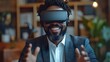 © Warakorn - Enthusiastic businessman at his office desk, smiling broadly as he uses VR goggles to interact with a virtual setting, making animated gestures.